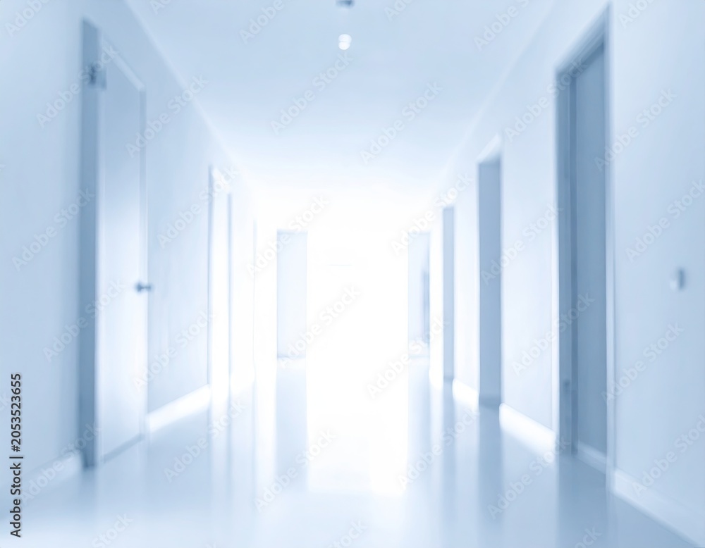 Fototapeta premium Long, blurred hallway with doors in cool, monochromatic tones, leading towards bright light