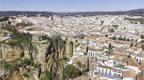 Ronda, Spain HDR wide drone video - Aerial view of the Andalusian city of Ronda perched high on a cliff with the iconic stone arch Puente Nuevo bridge spanning the El Tajo gorge.