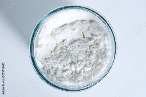 Fotografi Maizena flour in glass jar isolated on horizontal white background from top angle view