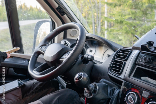 Driver cockpit of modern campervan parked in Finnish forest during summer road trip