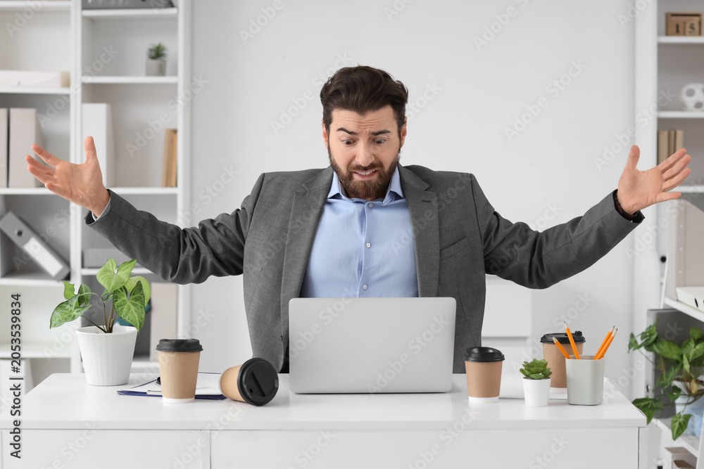 Naklejka premium Frustrated businessman reacting to computer problem in office, stressful work situation, technology failure, business challenges