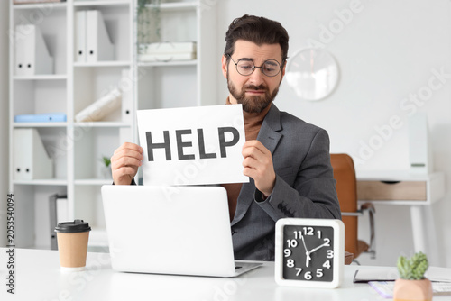 Overwhelmed businessman hol...