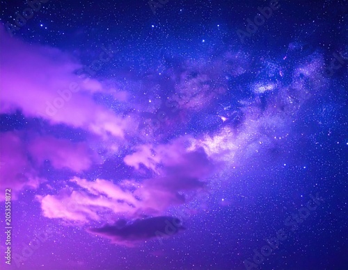 A dreamy nighttime sky with purple-tinged clouds and a vibrant, star-filled, cosmic backdrop