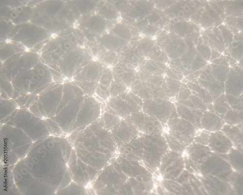 Abstract water caustic light patterns creating bright reflective textures, perfect for summer, pool and luxury backgrounds.