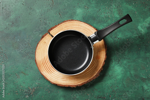 Obraz na płótnie Empty black frying pan on natural wood slice, kitchen utensil for cooking and fo