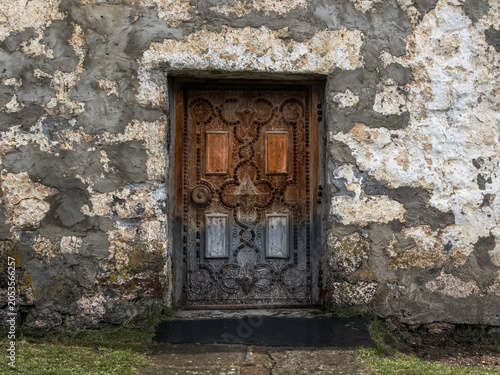 Antique wooden door is decorated with intricate carvings
