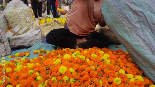 Vendor weighing fresh marigold flowers for sale