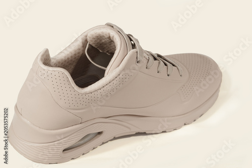 Beige athletic sneaker seen from rear three-quarter angle