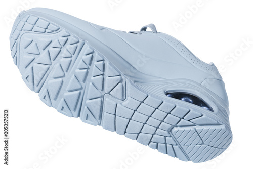 Isolated white sports sneaker levitating against a seamless white background. The image highlights the textured rubber outsole with triangular and grid tread