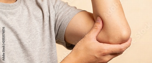 Hands Examining Elbow Joint for Pain or Injury Assessment