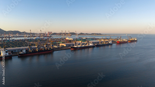 Commercial Port with Cargo Ships and Containers at Dusk