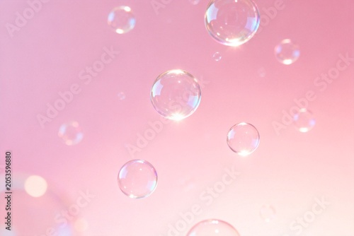 Floating soap bubbles on pink gradient background