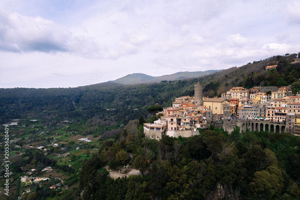 Obraz premium Hilltop Italian village surrounded by green forest
