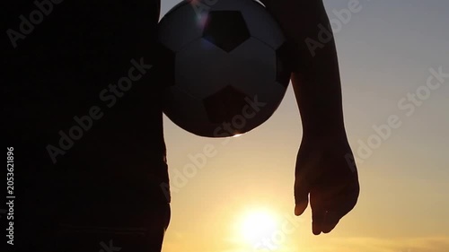 Silhouetted player holds a soccer ball against the setting sun. This image embodies the spirit and anticipation for the 2026 World Cup across USA and Canada