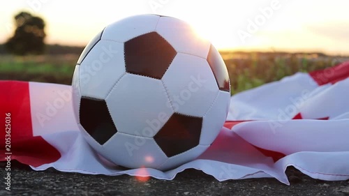 A classic soccer ball rests on a Canadian flag as the sun sets over a field. This image evokes the excitement and spirit surrounding the upcoming 2026 World Cup hosted by Canada and USA