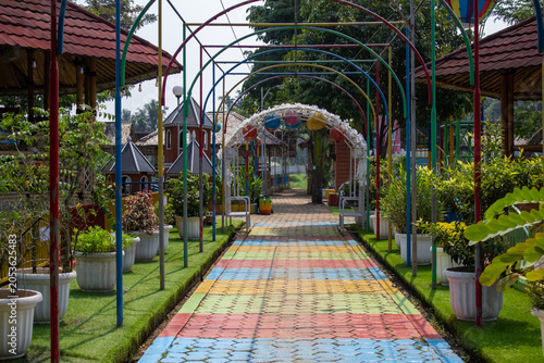 фотографія Colorful painted paving block pathway under metal arches in a vibrant public park