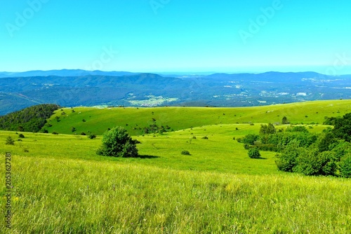 Green grassland at Vremščica hill with Brkini in the distance in Primorska, Slovenia