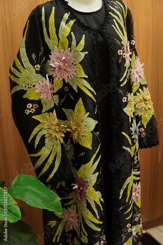 Cuadro en lienzo Elegant black long kaftan dress with colorful floral embroidery displayed on a mannequin