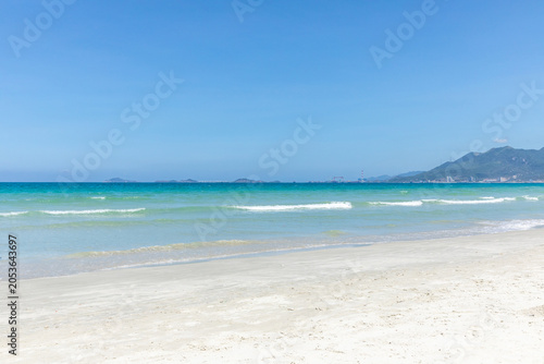 Fotografia Serene beach landscape featuring clear turquoise waters and gentle waves lapping
