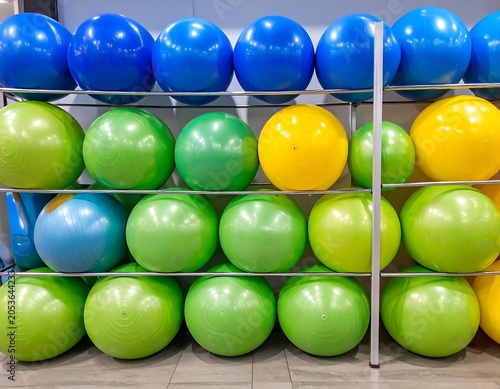Several rows of colorful exercise spheres are arranged on a metal rack, offering a diverse palette of fitness equipment