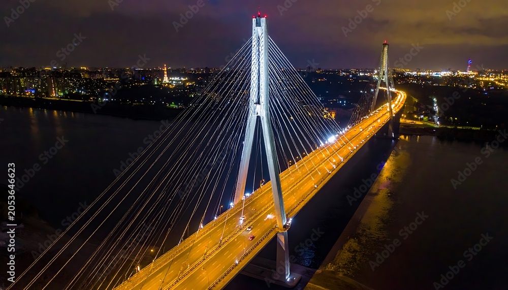 Fototapeta premium A nighttime aerial view of a large cable-stayed bridge over a body of water