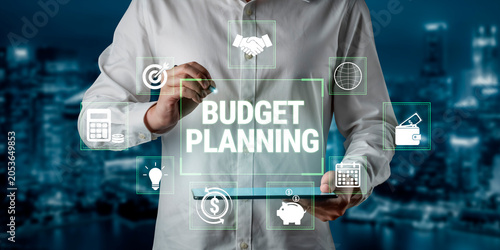Tableau sur toile Person Engaging in Digital Budget Planning with Graphical Financial Icons on a Futuristic Background in Urban Setting Fluxor