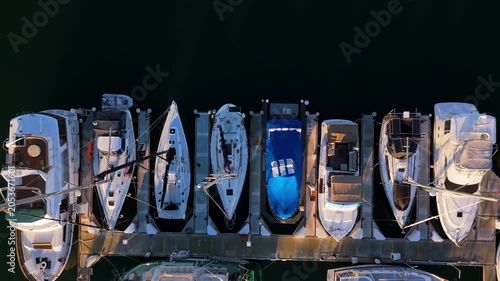 Top down aerial of luxury yachts docked in marina harbor, March 10, 2026