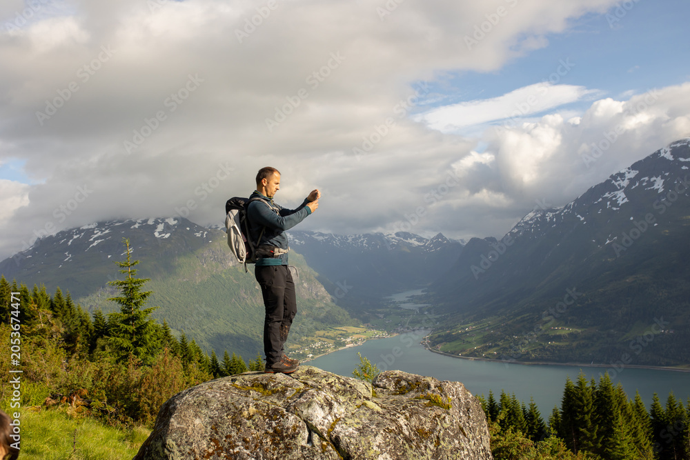Obraz premium People, adult with kids and pet dog, hiking mount Hoven, enjoying the splendid view over Nordfjord from Loen skylift