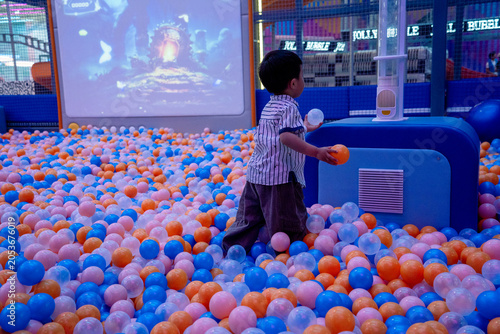 Young Boy Playing in Colorful Ball Pit at Indoor Playground
