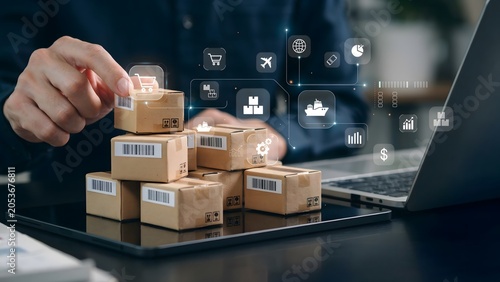Close-up of a person arranging small delivery boxes stacked on a tablet device, with digital icons representing e-commerce and logistics overlaid