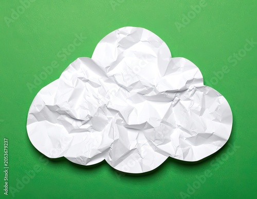 White crumpled paper cloud shape on a vibrant green background