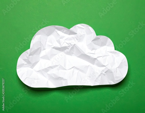 Crinkled white paper cloud rests on a vibrant green surface
