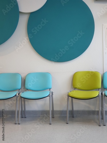 Blue and green chairs in hospital waiting area