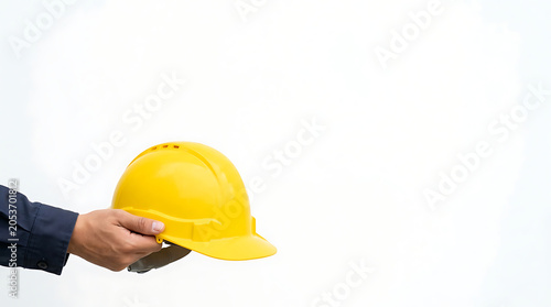 Hand holding yellow hard hat isolated on a clean white background