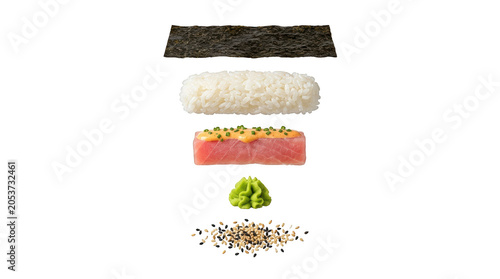 Ingredients for making fresh sushi roll including nori seaweed rice raw tuna fish spicy mayo wasabi paste and sesame seeds arranged in a vertical layer stack