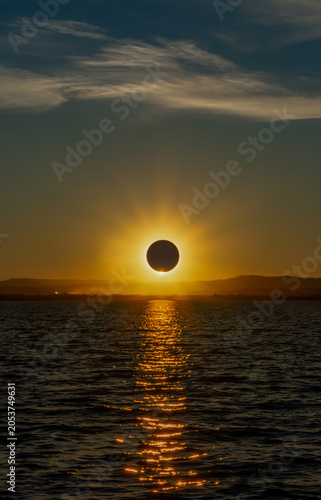 Fotografía Total solar eclipse over a coastal lagoon at sunset with a spectacular reflection of the sun in the water in the Albufera of Valencia, Spain
