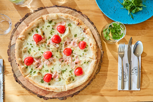 Quadro su tela Homemade pizza with cherry tomatoes on wooden board