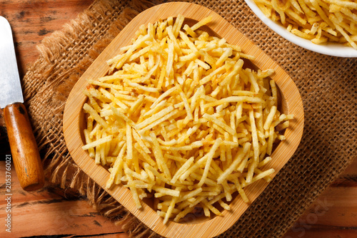 Canvas Print Portion of golden shoestring potatoes served on a rustic wooden serving platter,