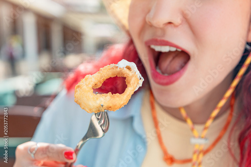 Foto Young woman on summer vacation eating fried calamari with lemon and aioli sauce