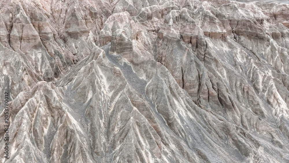 Obraz premium Mountains rise in dry terrain with rocky peaks and slopes under clear sky