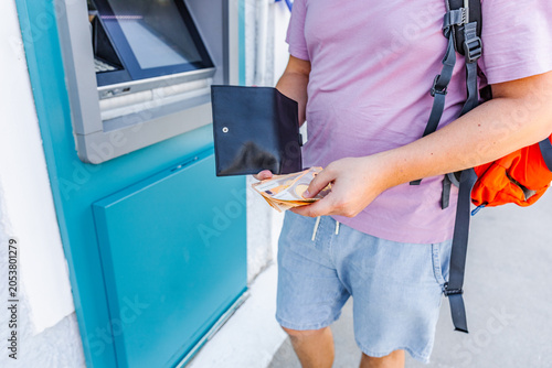 Foto Traveler withdrawing euro cash from an ATM during vacation abroad