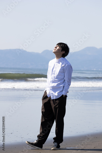 波打ち際を歩く男性