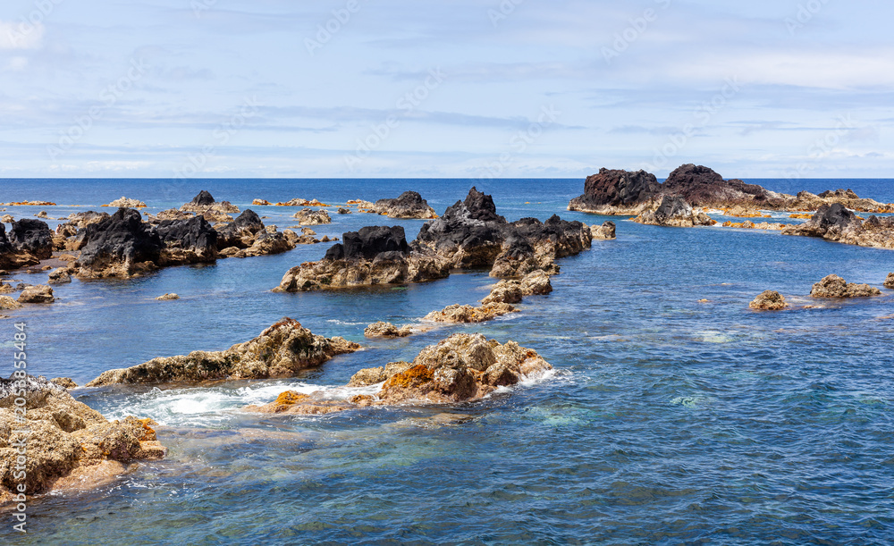 Fototapeta premium Mosteiros Natural Pools in Sao Miguel, Azores. Volcanic rock formations in the Atlantic Ocean. Clear blue waters and rugged coastline of Portugal.