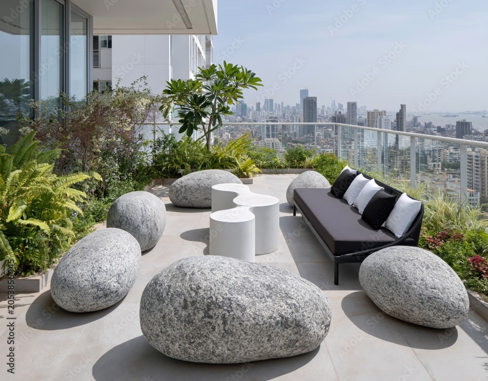 Naklejka premium Modern rooftop patio with unique stone seating and city skyline view, perfect for luxury living