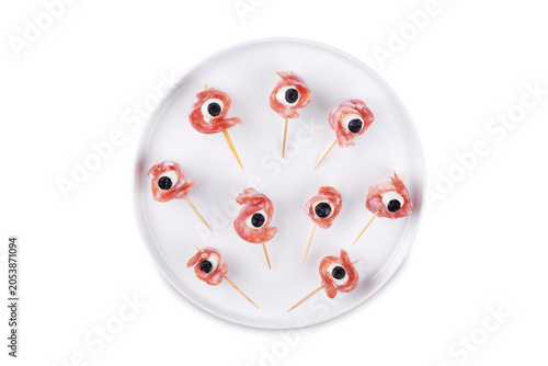 Mozzarella sausage olive canape in the form of eye in a plate on a white isolated background