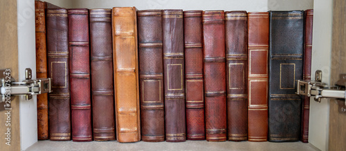 Antique leather bound books collection in cabinet. Set of ancient law book on bookshelf in college library. Old literature and history for knowledge archives. Education research concept