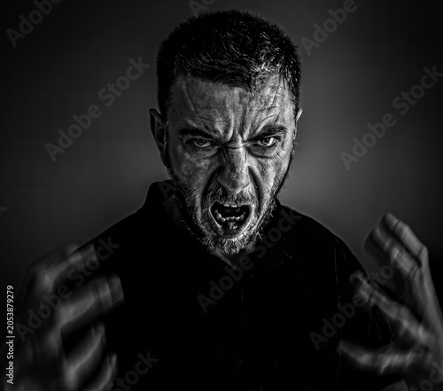 Фотография Angry man screaming in rage expressing stress and frustration