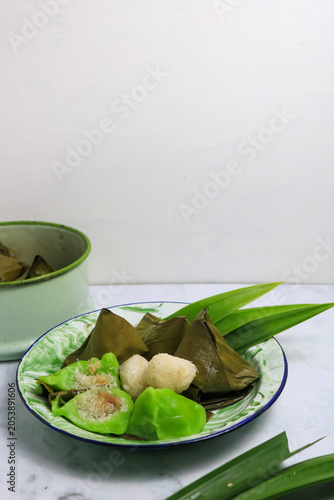 Traditional Indonesian Mendut cake with pandan leaves. Javanese sweet snack is made from glutinous rice flour, coconut and palm sugar, then wrapped in banana leaves and steamed. white backround.