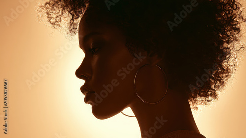 Silhouette curly hair afro hair hoop earring profile woman sunset backlight shadow glow female beauty hairstyle fashion elegance studio moody dramatic golden halo soft light contour side view neck