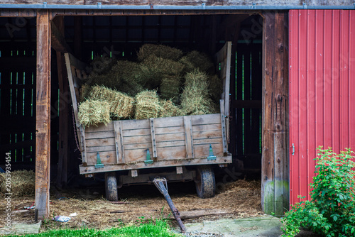 Barn with hay bales on a cart in rural setting near the farm
